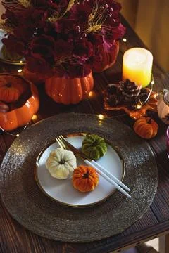Autumnal table setting with decorative pumpkins, candles and string lights Foto stock