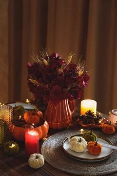 Autumnal table setting with decorative pumpkins, candles and string lights Foto stock