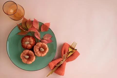 Autumnal table setting with decorative pumpkins, golden cutlery, and autumn.. Stock Photos