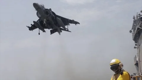 AV-8B Harrier hovering above USS Boxer ready to conduct vertical landing Stock Footage 114001259
