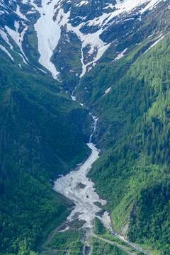 Avalanche path cutting through green alpine valley Stock Photos