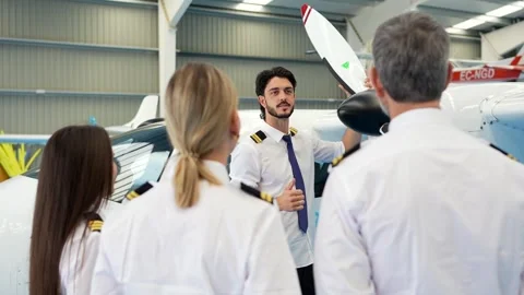 Aviation instructor explaining propeller mechanics to pilot students Stock Footage 336380165