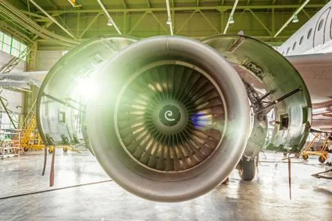 Aviation maintenance inside hangar with a flash light inspects airplane engin Fotos Stock