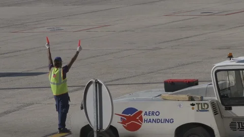 Aviation marshall signals to approaching plane with marshalling wand v2 Stock Footage 119826598