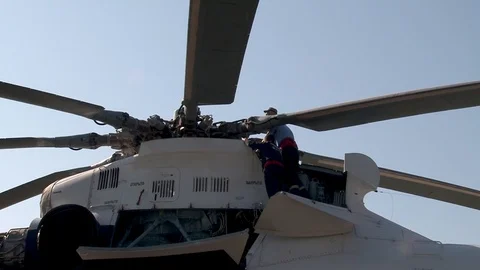 Aviation specialists perform maintenance in the engine compartment to helicopter Stock Footage 106232216