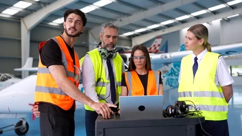 Aviation team discussing flight operations in hangar Stock Footage 336380230