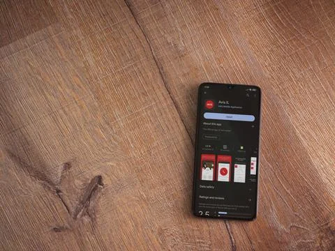 Avis IL app play store page on smartphone on wooden background Stock Photos