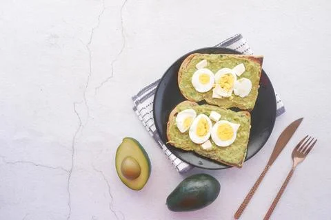 Avocado and egg on slice of a brown bread on white background Stock Photos