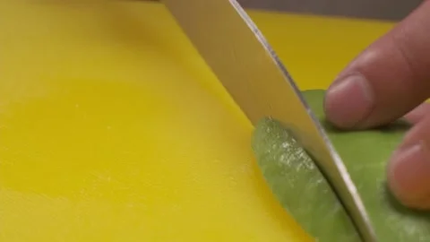 Avocado being cut into slices on a board by a chef Stock Footage 212414787