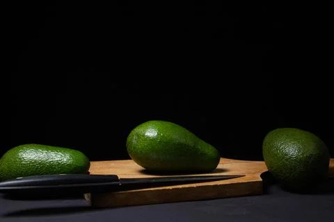 Avocado on a black background.  Stock Photos