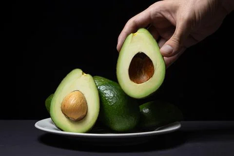 Avocado on a black background. Stock Photos