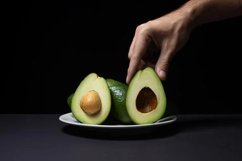 Avocado on a black background. Stock Photos