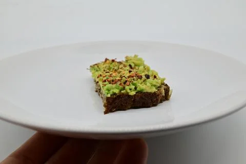 Avocado bread on a black rye bread Stock Photos