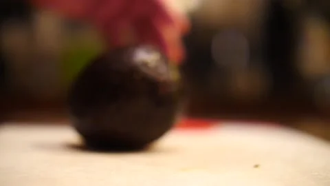 Avocado falling open rolling on table in slow motion close up Video stock 205257375