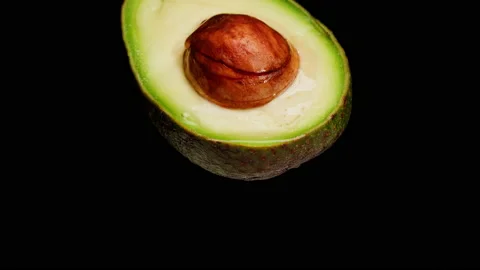 Avocado half isolated on black background chroma key, Fresh Sliced Avocado close Stock Footage 195123024