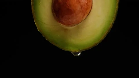 Avocado half isolated on black background chroma key, Fresh Sliced Avocado close Stock Footage 196882499
