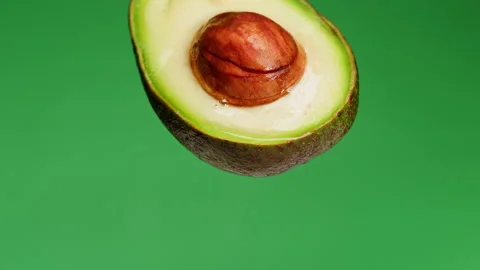 Avocado half isolated on green background chroma key, Fresh Sliced Avocado close Vidéo 197196526