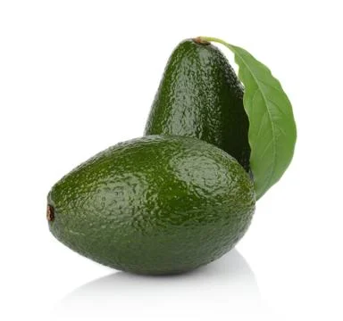 Avocado with leaf stands upright, vertically with whole avocado lying on the Stock Photos