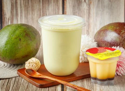 Avocado Milkshake in Plastic Cup with Pudding Dessert and Fresh Avocados on.. Stock Photos