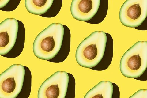 Avocado pattern on the yellow background healthy food Stock Photos