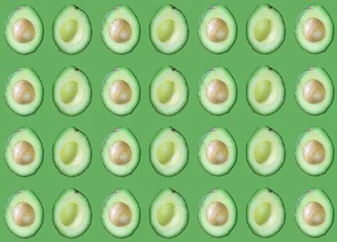 Avocado patterns with and without seed on green background Photos