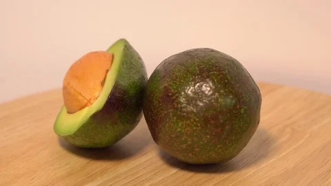 Avocado rotates on a wooden background Stock Footage 76544094