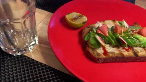 Avocado sandwich and serve on two plates red and blue dinner for two a slice of Stock Footage 292685997