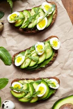 Avocado sandwich on dark rye bread made with fresh sliced avocados with spinach Stock Photos