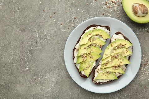 Avocado sandwich on dark rye bread made with fresh sliced avocados and seeds  Stock Photos