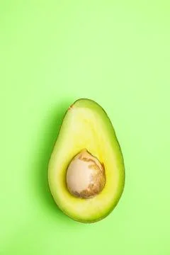 Avocado slice on the green background Stock Photos