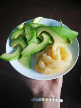 Avocado slices and fish caviar on the white plate Stock Photos