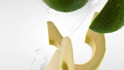 Avocado with Slices and Splash Falling on White Background Stock Footage 122704299