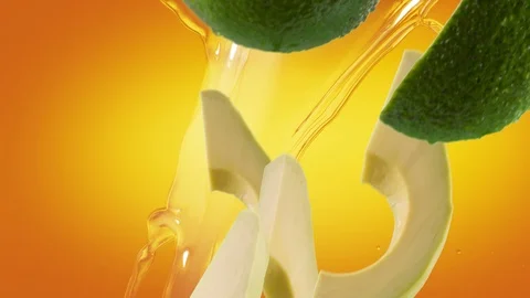 Avocado with Slices and Splash Falling on Orange Background Stock Footage 122704546