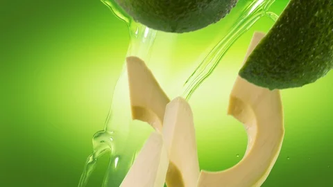 Avocado with Slices and Splash Falling on Green Background 스톡 동영상 122704703