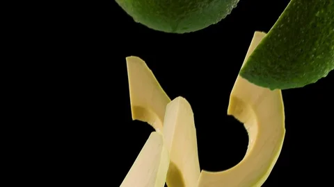 Avocado with Slices Falling on Black Background Stock Footage 122704346