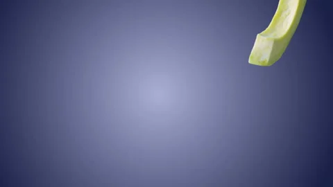 Avocado with Slices falling on blue background Stock Footage 130671227