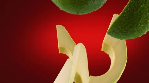 Avocado with Slices Falling on Deep Red Background Video stock 122703632
