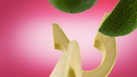 Avocado with Slices Falling on Pink Background Video stock 122704558