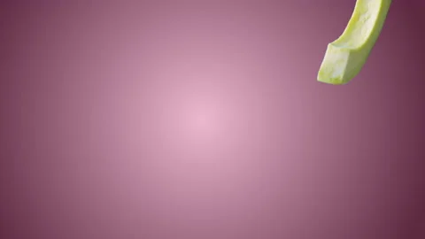 Avocado with Slices falling on pink background Stock Footage 130671647
