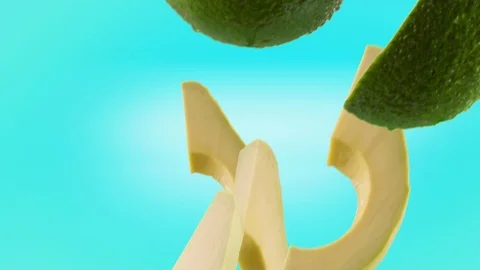 Avocado with Slices Falling on Turquoise Background Stock Footage 122703856