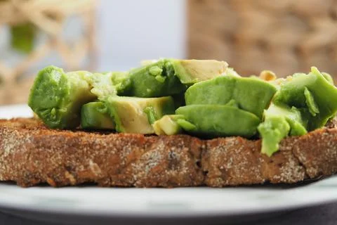 Avocado slices on toasted bread served in a kitchen setting Stock Photos