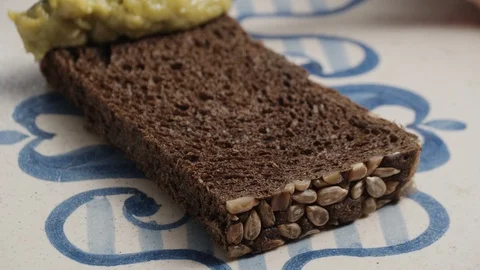 Avocado spread on the piece of dark bread Stock Footage 124623998