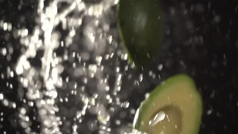 Avocado throw up with water splash droplets slow motion closeup Stock Footage 125338709