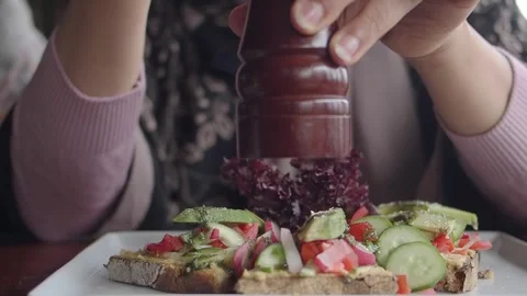 Avocado toast appears to be topped with fresh vegetables and pesto sauce Stock Footage 337810955