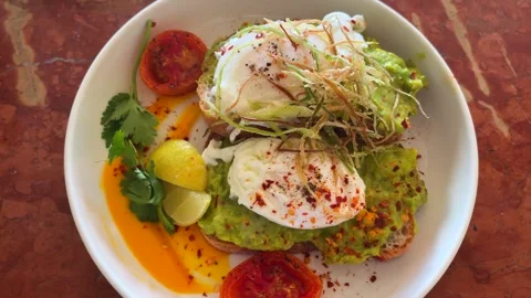 Avocado Toast with Poached Eggs Cafe Breakfast Plate Close Up Stock Footage 333827077