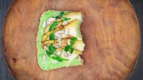 Avocado toast wit pear eating bite by bite. Loop stop motion animation. Video stock 129244705