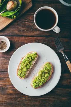 Avocado toasts and coffee on rustic table Foto stock