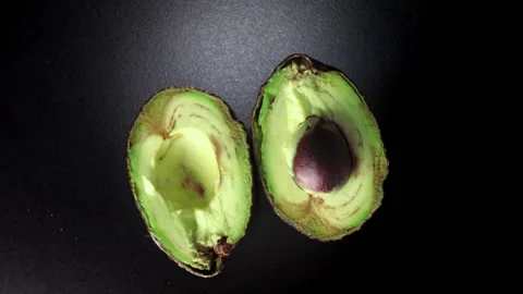Avocado in turn on black background Stock Footage 167338287