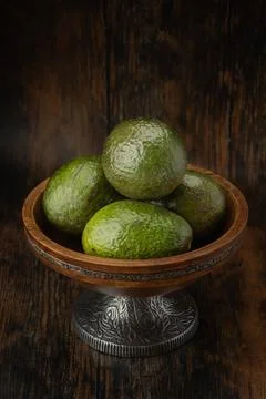 Avocados in a rustic bowl with a dark background Stock Photos