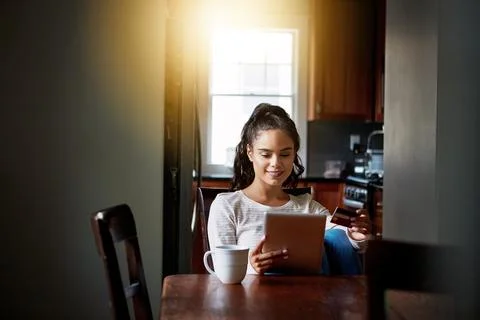 Avoid the lines and shop online. a young woman drinking coffee and shopping Stock Photos